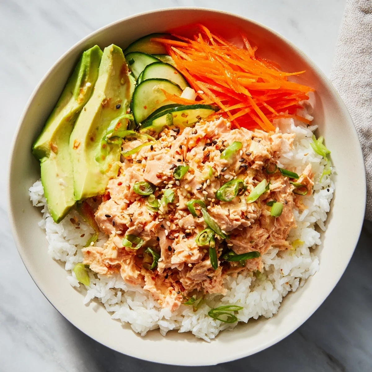 Flaky spicy canned salmon rice bowl with colorful veggies, a quick and delicious meal.