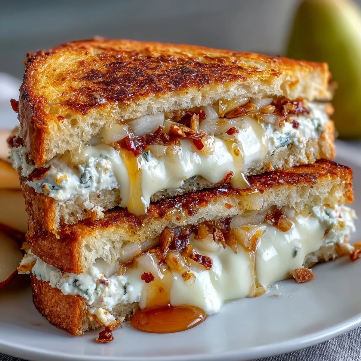 Freshly prepared goat cheese grilled cheese with honey and chili flakes on a cutting board, ready to be dipped in tomato soup.