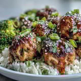 Golden-baked turkey meatballs coated in sticky honey-garlic sauce sit over fluffy rice and bright green steamed broccoli.