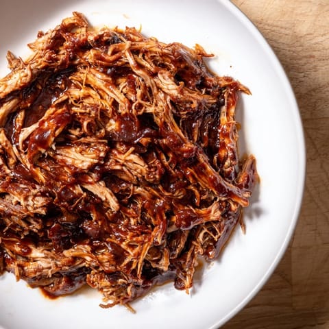 A close-up of smoky 5-Ingredient BBQ Pulled Pork piled high, ideal for delicious sandwiches or dinner.