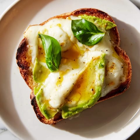 Avocado mozzarella tartine on a plate with a drizzle of olive oil, perfect for a quick, light lunch or appetizer.