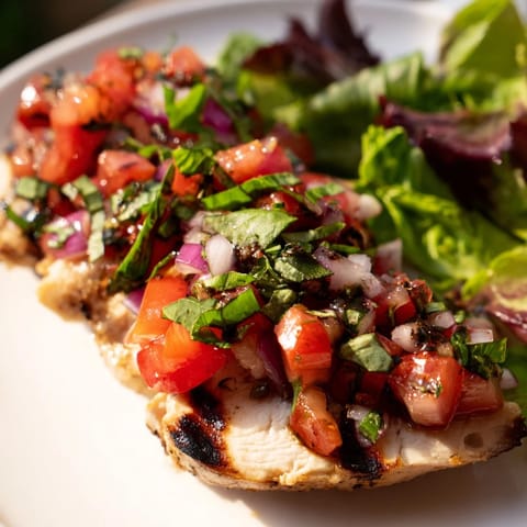 Bright salad with sliced grilled chicken, vibrant diced tomatoes, basil, and shaved Parmesan for an Italian-American main dish.  
