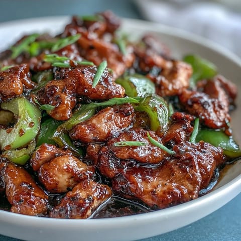 Freshly chopped green onions garnish this savory Black Pepper Chicken, ready to be served over rice.
