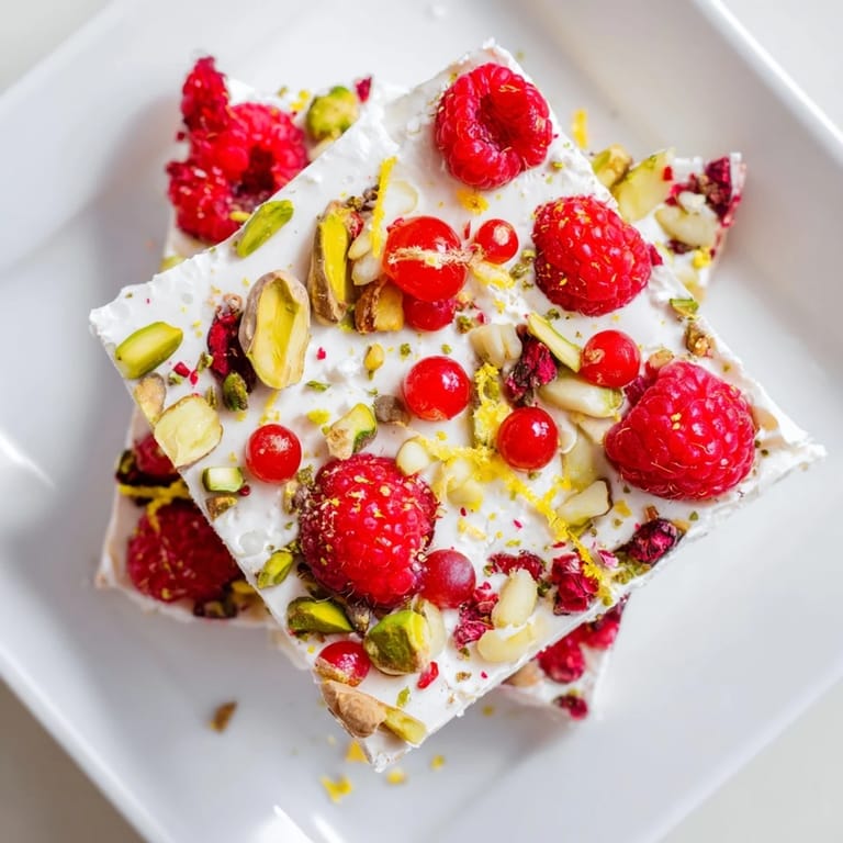 Enjoy a visual of colorful frozen yogurt bark with delicious berries and optional crunchy toppings.
