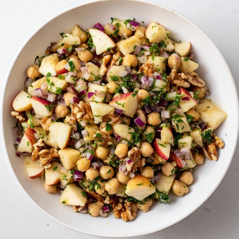 This Fall Harvest Apple and Chickpea Salad features colorful apples and crunchy walnuts tossed in a tangy dressing.