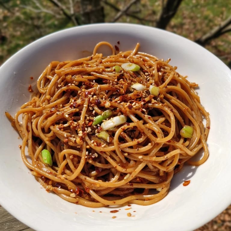 Flavorful Garlic Chili Oil Noodles, a quick and easy vegan meal, with visible chili flakes and sesame seeds.